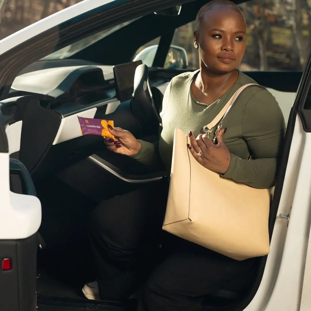 image of woman pulling a Consider This blueberry chia low histamine protien bar out of her bag