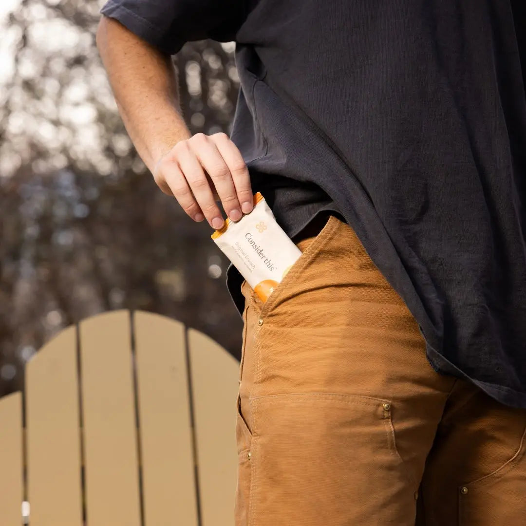 image of a man pulling a protein bar out of his pocket