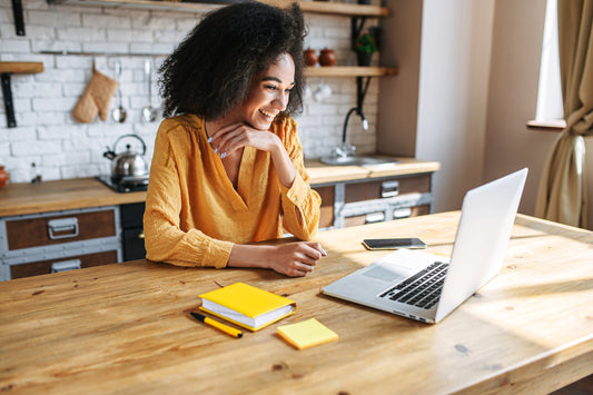 image of woman at computer with sunlight coming through an adjacent window