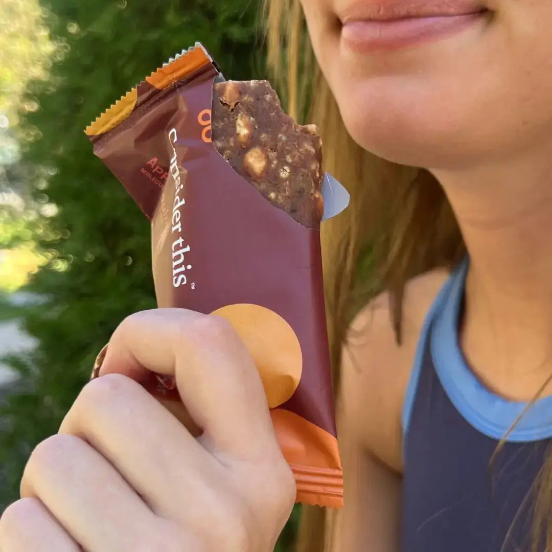 image of girl smiling and eating an apple quinoa low histamine protein bar